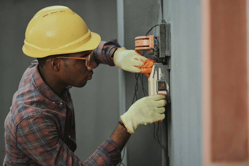 An electrician working on a wall fitting